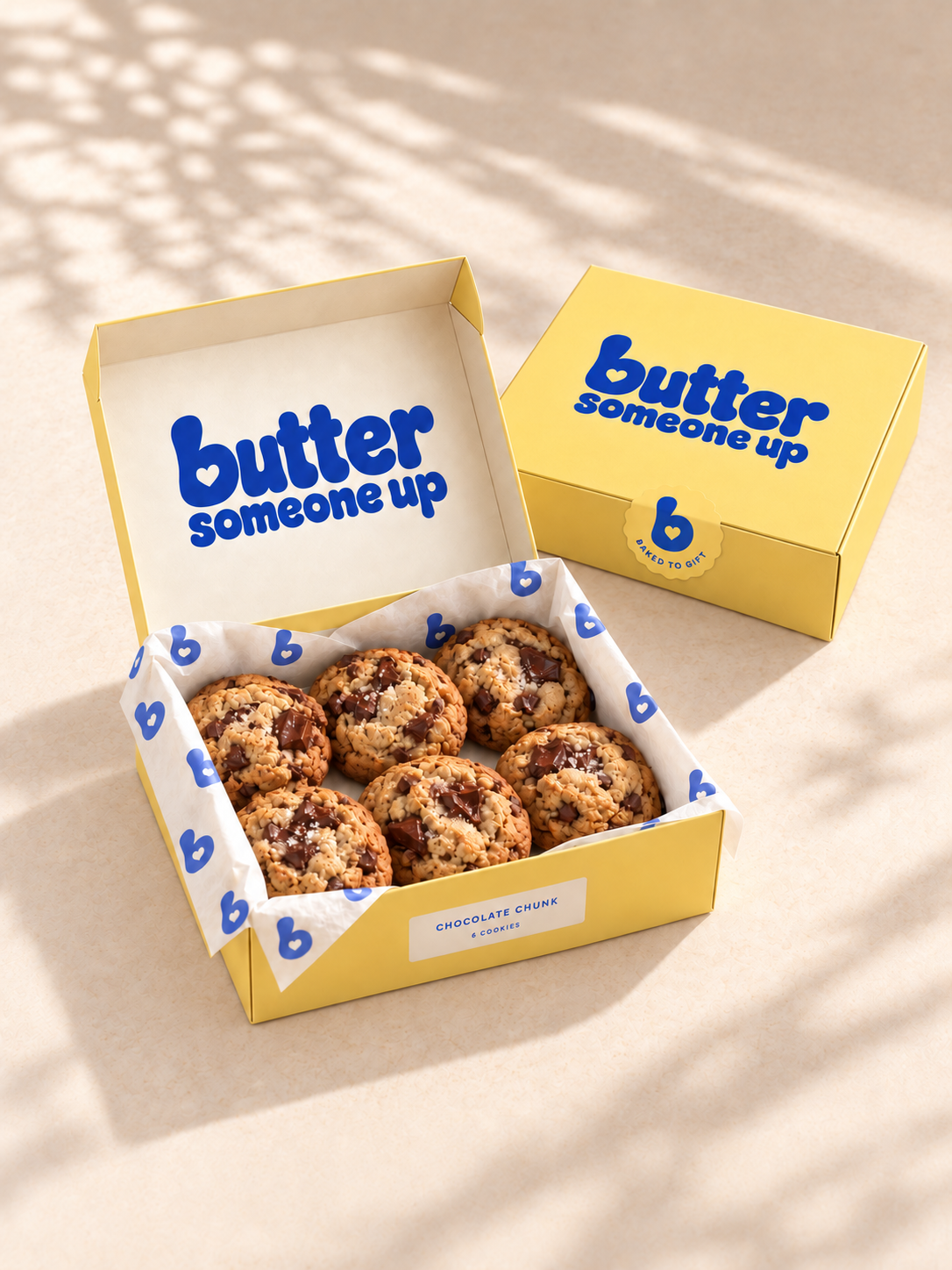 Butter-yellow gift boxes with chocolate chunk cookies and heart-patterned tissue
